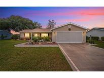 Charming single-story home featuring a manicured lawn and an attached two-car garage at 17806 Se 97Th Ct, Summerfield, FL 34491