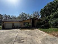 Well-maintained ranch-style home with an attached two-car garage, lush landscaping and mature trees at 18130 Keene Rd, Altoona, FL 32702
