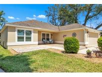 Inviting front exterior with a small sitting area, manicured lawn, and a well-maintained landscape at 1871 W Schwartz Blvd, Lady Lake, FL 32159