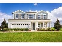 Beautiful two-story home featuring manicured lawn and inviting front porch at 2048 Airedale Way, Lake Alfred, FL 33850