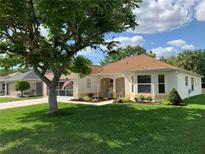 Charming single-story home featuring a well-manicured lawn and inviting front porch seating at 2256 Margarita Dr, The Villages, FL 32159