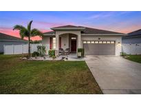 Charming single-story home featuring a well-manicured lawn, palm tree, and covered front porch at 37045 Scenic Ridge Dr, Grand Island, FL 32735