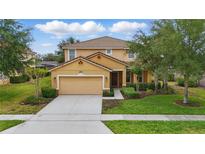 Charming two-story home with manicured lawn, beautiful landscaping, and neutral color palette at 4147 Oaktree Dr, Davenport, FL 33837