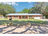 Charming single-story brick home with a well-manicured front lawn and a metal roof at 42116 E Lakeview Dr, Altoona, FL 32702