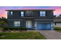 Charming two-story home showcasing stone accents, a well-manicured lawn, and blue shutters against a gray exterior at 524 Avila Pl, Howey In The Hills, FL 34737