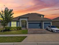 Beautiful single Gathering home with a three car garage, landscaped yard and warm sunset at 533 Avila Pl, Howey In The Hills, FL 34737
