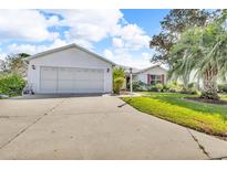 Charming single-story home with a well-maintained lawn, mature trees, and a spacious two-car garage at 767 Barbados Pl, The Villages, FL 32162