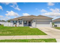Charming single-story home with a well-manicured lawn and a two-car garage at 15287 Aquarius Way, Mascotte, FL 34753