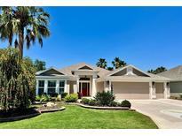 Charming single-story home featuring a well-manicured lawn, mature landscaping, and a three-car garage at 1985 Abordale Ln, The Villages, FL 32162