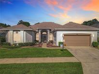 Charming single-story home featuring a well-manicured lawn and a two-car garage at 25523 Maurepas Ln, Leesburg, FL 34748