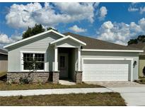 Charming single-story home featuring stone accents, neutral colors, and a well-manicured lawn at 3070 Sunscape Ter, Groveland, FL 34736