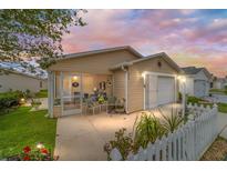 Inviting single-story home boasts a screened porch, attached garage, and manicured landscaping at 312 Emmalee Pl, The Villages, FL 32162