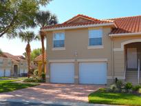 Charming two-story home with red tile roof, twin garages, and brick driveway at 5373 Compass Pt # 1, Oxford, FL 34484