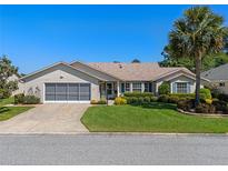 Charming single-story home featuring a well-manicured lawn, mature landscaping, and a screened two-car garage at 6608 Borg, Leesburg, FL 34748