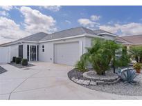 Charming one-story home featuring a two-car garage and well-manicured landscaping at 7382 Se 167Th Zina Ln, The Villages, FL 32162
