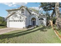 Charming two-story home featuring arched entryway, manicured lawn, and attached two-car garage at 981 Piedmont Oaks Dr, Apopka, FL 32703