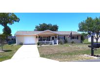 Charming single-story home featuring an attached garage, front porch with white picket fence, and well-maintained landscaping at 11250 Sw 78Th Ct, Ocala, FL 34476