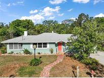 Charming single-story home features a brick walkway and a freshly painted exterior with mature trees at 1313 Crestview Dr, Mount Dora, FL 32757