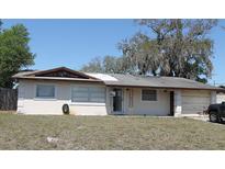 Single story home with front yard featuring an asphalt driveway and gray, weathered roof at 1400 Kirby St, Ocoee, FL 34761