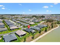 A beautiful aerial view of the homes and landscaping of this quiet community near a pond on a sunny day at 2001 Dagenais Way, The Villages, FL 32163