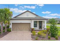 Charming one-story home with a well-manicured lawn, paver driveway, and a two-car garage at 2129 Palm Tree Dr, Poinciana, FL 34759