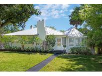 Charming one-story home featuring a metal roof, lush landscaping, and a well-manicured front lawn at 306 N Clayton St, Mount Dora, FL 32757