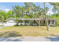 Charming single-story home with attached garage, mature landscaping and a well-manicured lawn at 3075 Cr 431N, Lake Panasoffkee, FL 33538