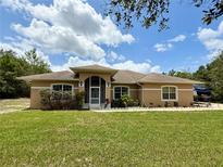Charming one-story home featuring a well-manicured lawn and inviting arched entryway at 31728 Nutmeg Ave, Eustis, FL 32736