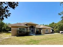 Inviting single-story home featuring a screened front entry and manicured lawn at 31728 Nutmeg Ave, Eustis, FL 32736