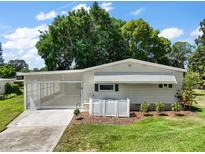 Charming single-story home with a screened carport and well-manicured lawn, perfect for relaxing outdoors at 34407 Island Dr, Leesburg, FL 34788