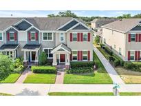 Beautiful townhome with well-maintained landscaping, red shutters, and a cozy front porch at 644 Orange Belt Loop, Winter Garden, FL 34787