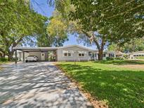 Charming single-story home with well-maintained lawn, carport, and mature trees at 715 Megan Circle, The Villages, FL 32159