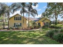 Charming yellow two-story home featuring mature landscaping, a welcoming walkway, and beautiful curb appeal at 848 Hawk Lndg, Fruitland Park, FL 34731