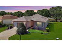 Charming single-story home featuring a well-manicured lawn and a two car garage at 9593 Se 124Th Loop, Summerfield, FL 34491