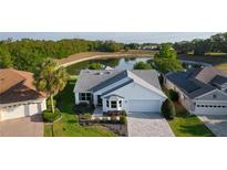 Aerial view of a charming home with a lake view and well-manicured lawn at 1142 Salido Ave, The Villages, FL 32159