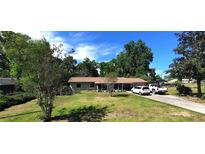 Charming single-story home with a well-maintained lawn, mature trees, and a private driveway, offering a serene and welcoming atmosphere at 1431 Ne 53Rd St, Ocala, FL 34479