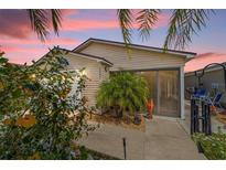Charming home with flowering shrubs, a cute palm tree and a screened in lanai at 2095 Thornton Ter, The Villages, FL 32162