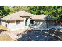 Charming single-story home with a well-maintained lawn and a welcoming green front door at 2420 Sr 471, Sumterville, FL 33585