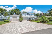 Beautiful two-story home with a long brick driveway and a three-car garage at 26516 Savage Cir, Howey In The Hills, FL 34737