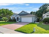 Charming one-story home featuring a well-manicured lawn, a two-car garage, and a beautifully landscaped front yard at 2749 Wilshire Rd, Clermont, FL 34714