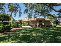 Beautiful brick home featuring a lush lawn, manicured landscaping, and a clay tile roof at 301 Waterwood Dr, Yalaha, FL 34797