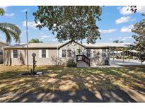 Charming single-story home featuring a metal roof, covered parking, and landscaped front yard at 37945 Monticello St, Leesburg, FL 34788