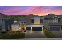 Beautiful two-story home with a two-car garage and professionally landscaped yard highlighted by a beautiful sunset at 4515 Lions Gate Ave, Clermont, FL 34711