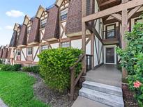 Exterior view of Tudor-style townhome with lush landscaping and private entrance at 500 Newell Hill Rd # 111A, Leesburg, FL 34748