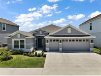 Charming single-story home with a manicured lawn and a spacious three-car garage at 7669 Chastain Cir, Middleton, FL 34762