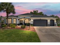Charming single-story home featuring a well-manicured lawn and a two-car garage at 8715 Se 176Th Lowndes Pl, The Villages, FL 32162