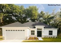 Charming single-story home featuring an attached two-car garage and a well-manicured front yard at 8742 Se 158Th Pl, Summerfield, FL 34491