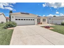 Charming single-story home featuring a two-car garage, solar panels, and well-maintained landscaping at 9621 Se 168Th Maplesong Ln, The Villages, FL 32162