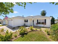 Inviting single-story home with neatly landscaped front yard and an attached garage at 17076 Se 96Th Chapelwood Cir, The Villages, FL 32162