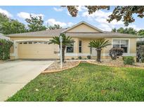 Charming single-story home with a well-manicured lawn and inviting two-car garage at 17238 Se 94Th Coults Cir, The Villages, FL 32162